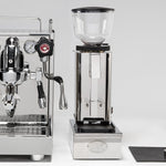 ECM Mechanika Slim VI espresso machine beside an ECM grinder and knock box drawer